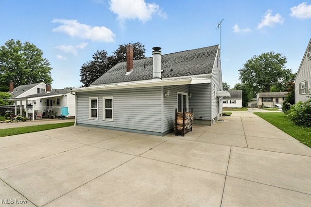 3692 Orchard St, Mogadore, OH 44260 - back of house with roof with shingles, a patio, and a chimney
