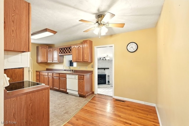 3692 Orchard St, Mogadore, OH 44260 - kitchen with dishwasher, a ceiling fan, black electric cooktop, a fireplace, and light wood-style flooring