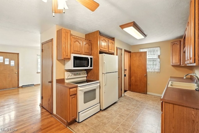 3692 Orchard St, Mogadore, OH 44260 - kitchen featuring white appliances, ceiling fan, brown cabinetry, and a textured ceiling