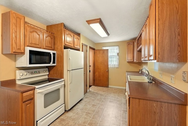 3692 Orchard St, Mogadore, OH 44260 - kitchen with white appliances, brown cabinets, a textured ceiling, and dark countertops