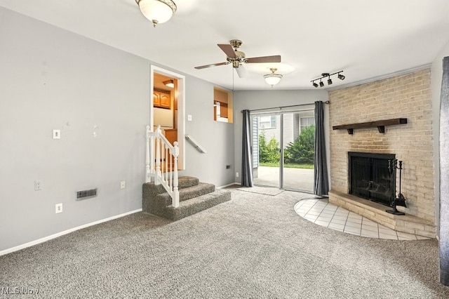 3692 Orchard St, Mogadore, OH 44260 - unfurnished living room with carpet floors, ceiling fan, stairs, track lighting, and a fireplace