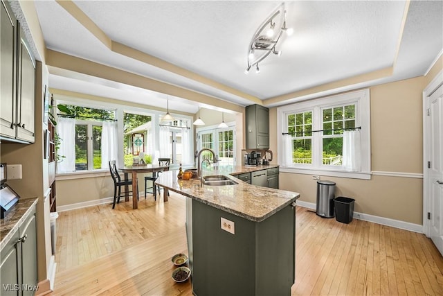 6735 Wakefield Rd, Hiram, OH 44234 - kitchen featuring light stone countertops, gray cabinetry, light wood finished floors, a peninsula, and decorative light fixtures