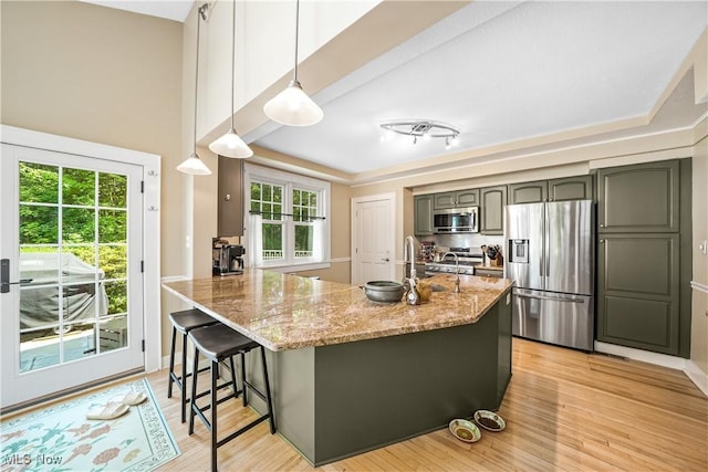 6735 Wakefield Rd, Hiram, OH 44234 - kitchen featuring stainless steel appliances, light stone countertops, a kitchen bar, light wood-style floors, and gray cabinets
