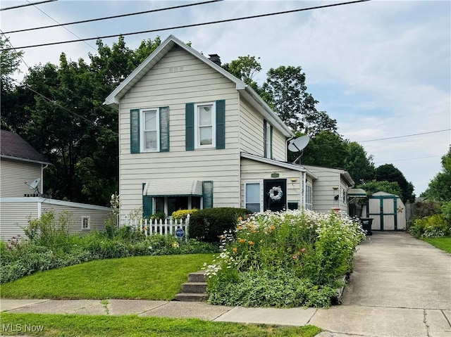 134 E Summit St, Alliance, OH 44601 - view of front facade featuring a storage shed, a chimney, and a front yard