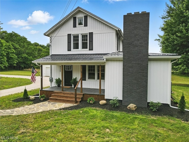 4930 S Ridge Rd W, Ashtabula, OH 44004 - modern inspired farmhouse featuring a porch, a chimney, a front lawn, and a metal roof