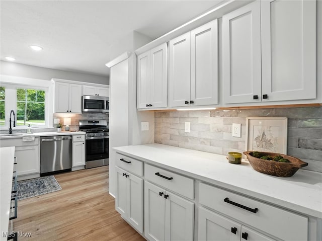 4930 S Ridge Rd W, Ashtabula, OH 44004 - kitchen featuring stainless steel appliances, decorative backsplash, white cabinets, light wood-style floors, and recessed lighting