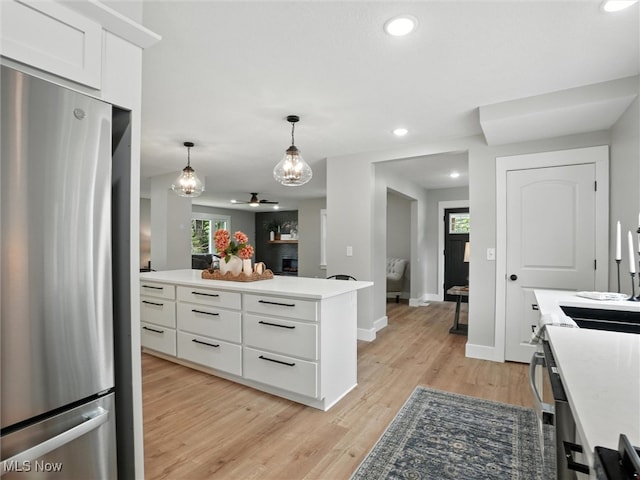 4930 S Ridge Rd W, Ashtabula, OH 44004 - kitchen featuring freestanding refrigerator, white cabinets, recessed lighting, pendant lighting, and light wood-style flooring