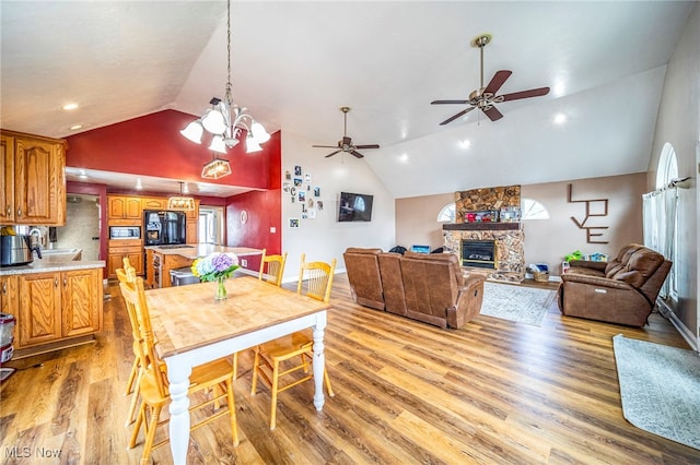 1743 Silver St, Wickliffe, OH 44092 - dining space with vaulted ceiling, light wood-type flooring, a stone fireplace, a ceiling fan, and recessed lighting