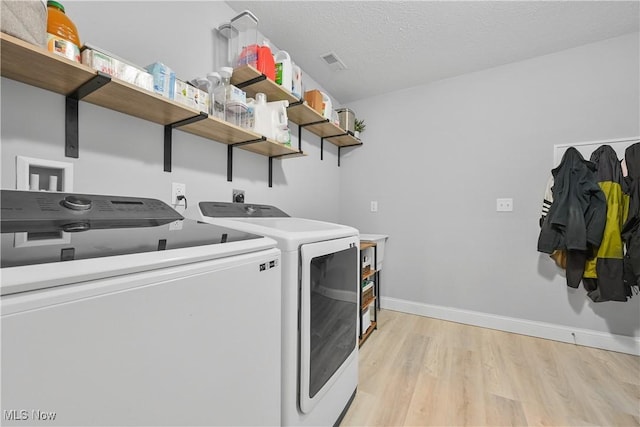 4933 Lear Nagle Rd, North Ridgeville, OH 44039 - laundry room featuring independent washer and dryer, light wood-style flooring, and a textured ceiling