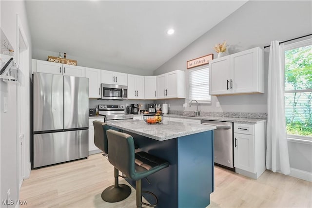 4933 Lear Nagle Rd, North Ridgeville, OH 44039 - kitchen with stainless steel appliances, white cabinetry, light wood finished floors, a center island, and recessed lighting