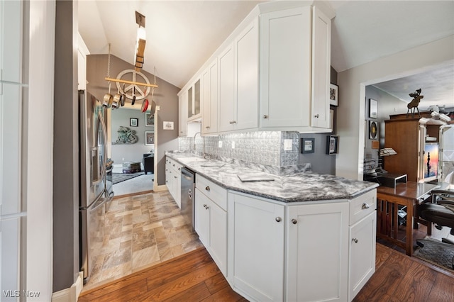 25171 Doe Dr, North Olmsted, OH 44070 - kitchen featuring a chandelier, vaulted ceiling, white cabinets, stainless steel appliances, and backsplash