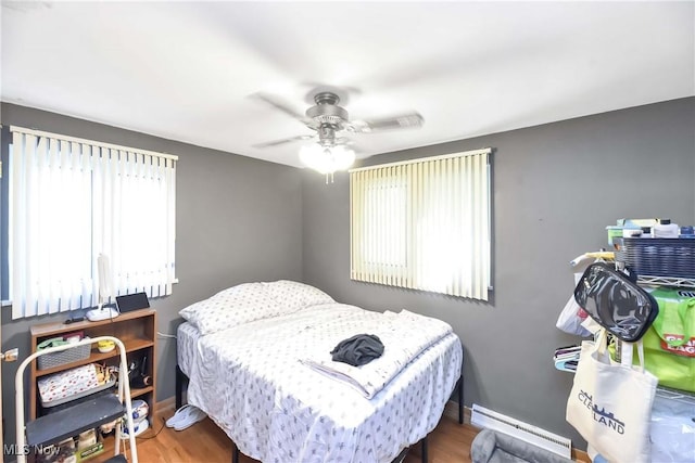 4480 W 224th St, Fairview Park, OH 44126 - bedroom featuring baseboard heating, a ceiling fan, and wood finished floors