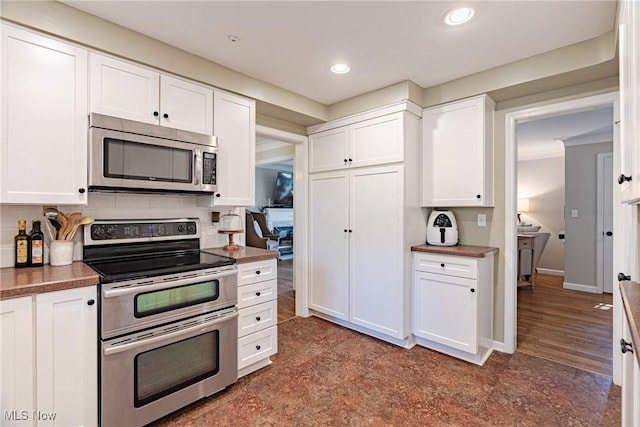 2383 Saybrook Rd, University Heights, OH 44118 - kitchen featuring appliances with stainless steel finishes, white cabinets, recessed lighting, dark countertops, and backsplash