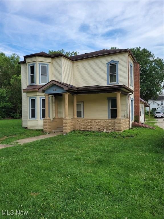 217 E 4th St, Warsaw, OH 43844 - view of front facade featuring a front lawn and stone siding