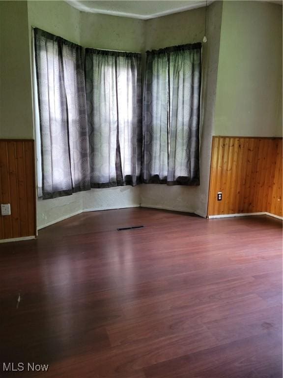 217 E 4th St, Warsaw, OH 43844 - empty room with wood finished floors, wainscoting, and wooden walls