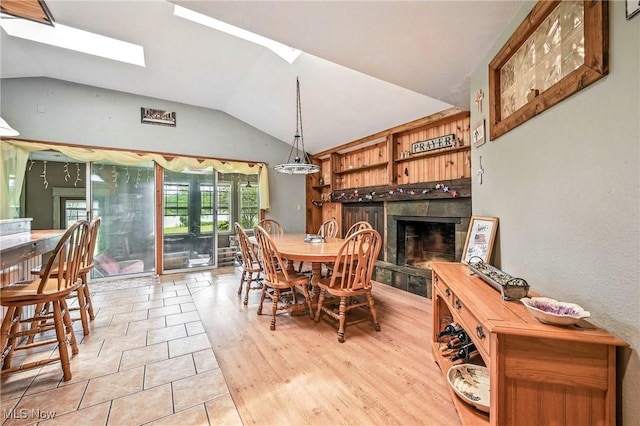 1173 Ridge Rd, Salem, OH 44460 - dining room with lofted ceiling, a fireplace with raised hearth, a skylight, and light tile patterned flooring