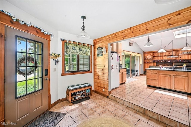 1173 Ridge Rd, Salem, OH 44460 - kitchen with freestanding refrigerator, healthy amount of natural light, vaulted ceiling, light tile patterned floors, and pendant lighting