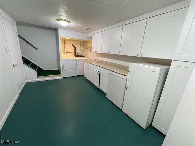 6466 Concord Rd Unit M4, Parma, OH 44134 - kitchen featuring independent washer and dryer, freestanding refrigerator, white cabinetry, a textured ceiling, and light countertops