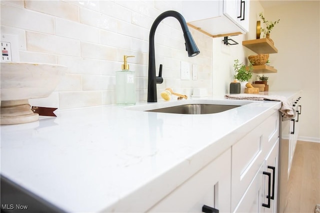 7142 N Oxshire Pl, Concord, OH 44077 - kitchen with open shelves, decorative backsplash, white cabinetry, and light wood-style flooring