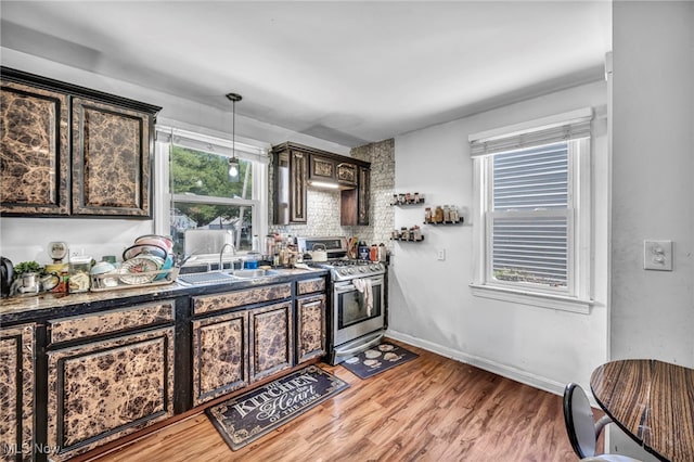 29100 Weber Ave, Wickliffe, OH 44092 - kitchen with stainless steel gas range oven, light wood-style flooring, dark brown cabinets, hanging light fixtures, and decorative backsplash