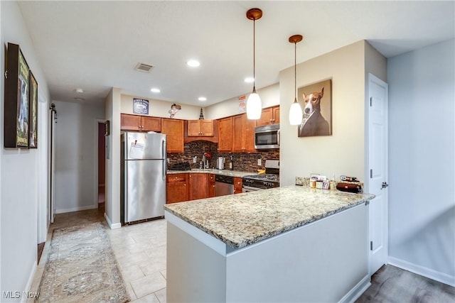 985 Canyon View Rd Unit 204C, Northfield, OH 44067 - kitchen with appliances with stainless steel finishes, a peninsula, tasteful backsplash, brown cabinetry, and hanging light fixtures