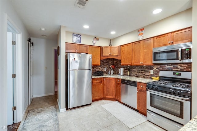 985 Canyon View Rd Unit 204C, Northfield, OH 44067 - kitchen with stainless steel appliances, tasteful backsplash, brown cabinets, light stone counters, and recessed lighting