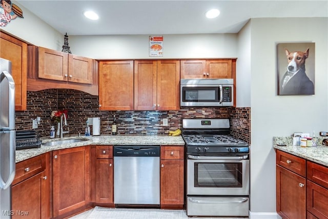 985 Canyon View Rd Unit 204C, Northfield, OH 44067 - kitchen with stainless steel appliances, light stone counters, tasteful backsplash, brown cabinetry, and recessed lighting