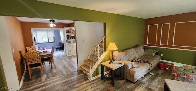 963 Chelston Rd, South Euclid, OH 44121 - living area with wood finished floors, a ceiling fan, and stairs