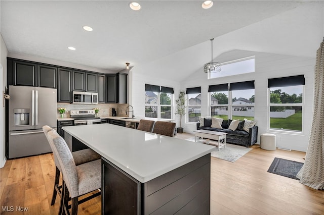 1383 Easton Way, Brunswick, OH 44212 - kitchen featuring appliances with stainless steel finishes, light countertops, vaulted ceiling, light wood-style flooring, and a kitchen island