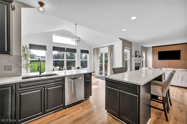 1383 Easton Way, Brunswick, OH 44212 - kitchen featuring a fireplace, open floor plan, stainless steel dishwasher, a kitchen bar, and light countertops