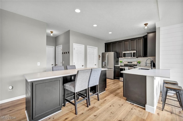 1383 Easton Way, Brunswick, OH 44212 - kitchen featuring appliances with stainless steel finishes, a breakfast bar, light countertops, light wood-style flooring, and recessed lighting