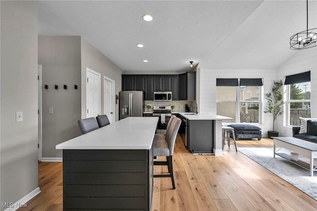 1383 Easton Way, Brunswick, OH 44212 - kitchen with appliances with stainless steel finishes, a breakfast bar area, light countertops, light wood-style floors, and recessed lighting
