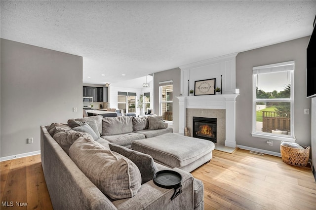 1383 Easton Way, Brunswick, OH 44212 - living area with light wood finished floors, a textured ceiling, a tile fireplace, and recessed lighting