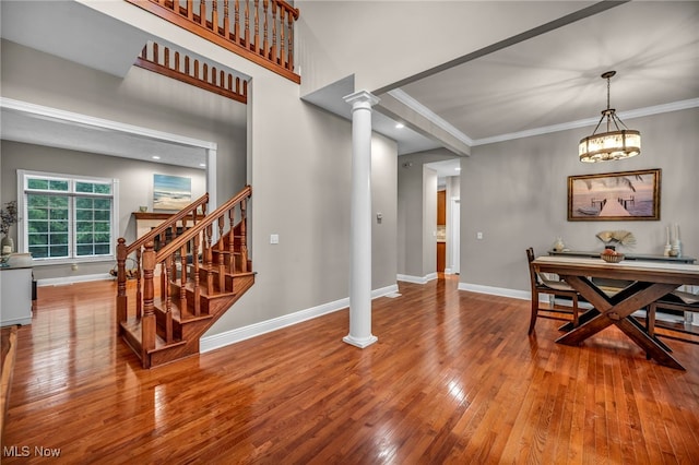 7955 Forest Valley Ln, Concord, OH 44077 - dining room featuring hardwood / wood-style floors, ornate columns, crown molding, stairs, and a chandelier