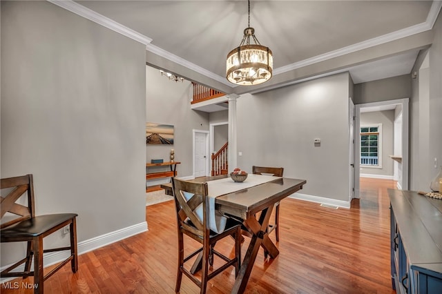 7955 Forest Valley Ln, Concord, OH 44077 - dining room featuring a chandelier, decorative columns, light wood-style floors, ornamental molding, and stairway