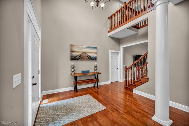 7955 Forest Valley Ln, Concord, OH 44077 - foyer entrance with ornate columns, stairs, a towering ceiling, wood finished floors, and a chandelier