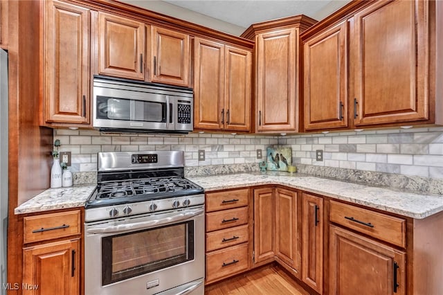 7955 Forest Valley Ln, Concord, OH 44077 - kitchen with stainless steel appliances, light wood-type flooring, brown cabinets, and backsplash