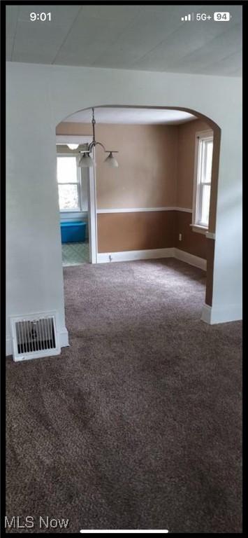 1405 Brandon Ave, Akron, OH 44305 - carpeted spare room with a chandelier, healthy amount of natural light, and arched walkways