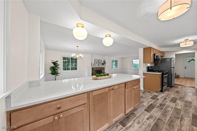 3695 S Hametown Rd, Norton, OH 44203 - kitchen featuring appliances with stainless steel finishes, dark wood finished floors, a peninsula, a chandelier, and decorative light fixtures