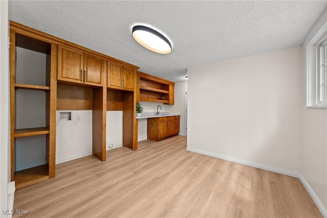 3695 S Hametown Rd, Norton, OH 44203 - kitchen featuring light wood finished floors, open shelves, a textured ceiling, brown cabinetry, and light countertops