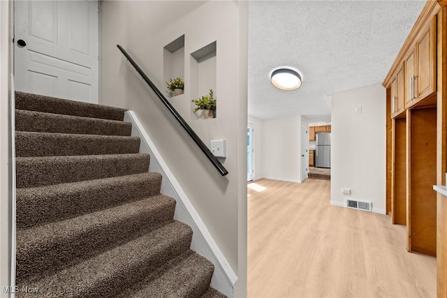 3695 S Hametown Rd, Norton, OH 44203 - stairway with wood finished floors and a textured ceiling
