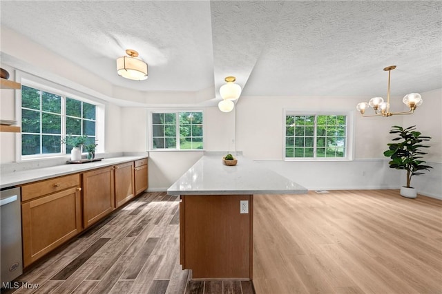 3695 S Hametown Rd, Norton, OH 44203 - kitchen with wood finished floors, plenty of natural light, brown cabinetry, a peninsula, and a textured ceiling