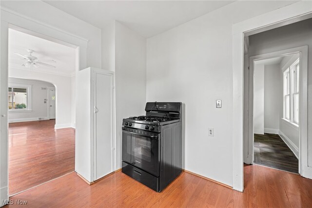 18830 Monterey Ave, Euclid, OH 44119 - kitchen featuring black range with gas cooktop, light wood-style flooring, arched walkways, and ceiling fan