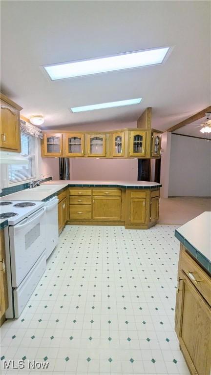 226 Troy Oaks Dr, Hiram, OH 44234 - kitchen with white appliances, brown cabinets, light flooring, and a skylight