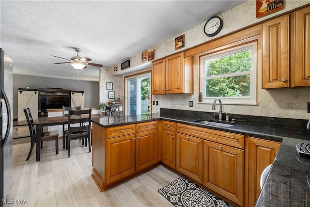 23730 Sawmill Bnd, Olmsted Falls, OH 44138 - kitchen with brown cabinetry, a peninsula, light wood-type flooring, and a textured ceiling