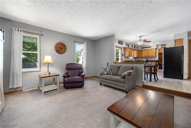 23730 Sawmill Bnd, Olmsted Falls, OH 44138 - living room with healthy amount of natural light, a textured ceiling, a ceiling fan, and light carpet