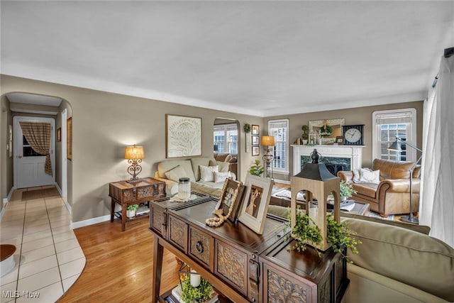 9013 Elsmere Dr, Parma, OH 44130 - living room with arched walkways, a premium fireplace, plenty of natural light, and light tile patterned floors
