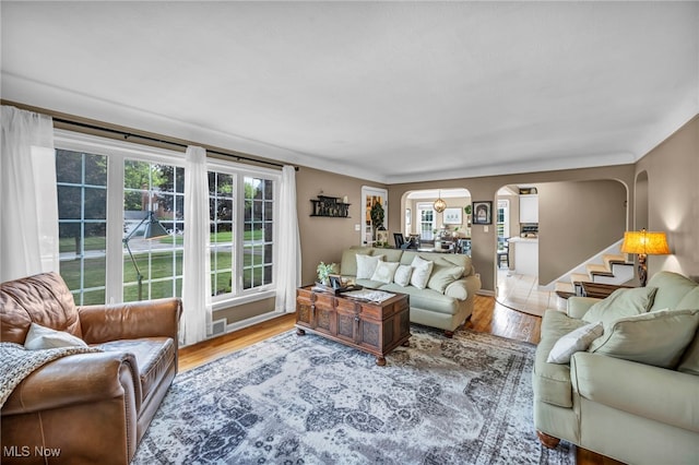 9013 Elsmere Dr, Parma, OH 44130 - living area featuring arched walkways, wood finished floors, and stairway