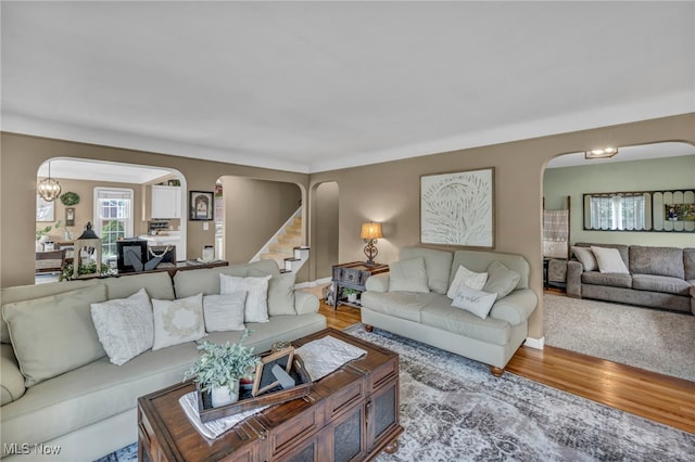 9013 Elsmere Dr, Parma, OH 44130 - living room with arched walkways, wood finished floors, and stairway
