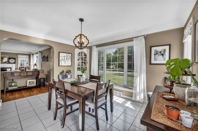 9013 Elsmere Dr, Parma, OH 44130 - dining area featuring arched walkways, tile patterned flooring, and a chandelier